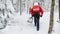 Rear view of mountain rescue service with shovels on operation outdoors in winter in forest.