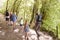 Rear View Of Multi Generation Family Enjoying Walk Along Woodland Path Together