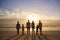 Rear View Of Multi Generation Family Silhouetted On Beach