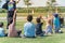 Rear view multicultural children on grass meadow raising hands in outdoor game