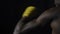 Rear view of muscular man boxing on black background. Afro american young male boxer practicing shadow boxing. Boxer in