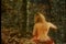 Rear view of a naked woman sitting in a forest
