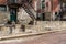 Rear view of old apartment buildings, sidewalk and red brick street, fire escapes and weathered walls and steps