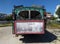 Rear view of an old rusting green painted bus with roof rack parked in a rustic location in cyprus