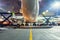 Rear view of the plane during midnight call service at the airport, food trucks on the sides amidst the light of lanterns