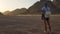 Rear view Portrait of a lonely woman watching a beautiful sunset in the mountains in Egypt. Young girl in the desert. Caucasian