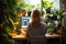 Rear view productivity Woman at computer with green plants nearby