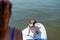 Rear view of a red-haired woman riding a stand-up paddle board with her dog. Portrait of a jack russell terrier surfing