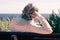 Rear view of a relaxed grey-haired woman sitting on a bench in front to the sea,  looking at the horizon. Senior woman enjoying