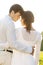 Rear view of romantic couple standing arms around against clear sky