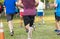 Rear view of runners racing on grass in a park