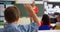 Rear view of schoolboy raising hand in the classroom 4k