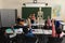 Rear view of schoolkids raising hands and sitting at desk in classroom