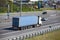 Rear view of semitrailer with blue container driving on highway