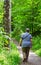 Rear view of Senior caucasian woman walking along wooden path in forest looking the nature,outdoor