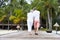 Rear View Of Senior Couple Walking On Wooden Jetty