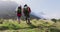 Rear view of senior hiker couple with backpacks and hiking poles holding hands