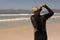 Rear view of senior male surfer wearing wet suit on the beach