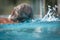 Rear view of a senior man swimming in a pool