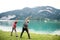 Rear view of senior pensioner couple by lake in nature, doing exercise.