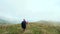 Rear-view shot of sports woman with a backpack and sticks who is hiking and walking on a mountain in the Caucasus