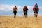 Rear view shot of young friends in countryside during summer holiday hiking. Group of hikers walking in the nature.