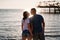 rear view. silhouettes of a man and a woman kissing in sunlight on the beach.