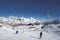 Rear view of skier with poles skiing on snowy landscape