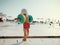 Rear view of small child with armbands walking on beach on summer holiday.