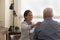 Rear view smiling female doctor comforting mature man, touching shoulder