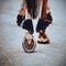 A rear view of a sorrel horse walking along a dusty road, stepping on it with shod hooves. Metal horseshoe close-up