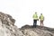 Rear view of supervisors standing at construction site against clear sky