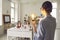 Rear view on teacher with lightbulb pointing at pupil sitting at classroom desk