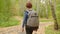 Rear view teenager boy with backpack walking on pathway in autumn park. Boy teenager choosing way on road fork in city