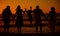 Rear view of a three generation family silhouetted on the beach while jumping together. Cheerful family with two