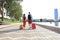 Rear view of tourist couple holding hands and dragging luggage, sightseeing visiting street, outdoors