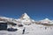 Rear view of tourist skiing on snowy landscape against mountain peak