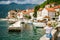 Rear view of a tourist woman taking a picture of the beatiful small town Perast