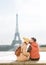 Rear view. tourists, man and woman sitting in front of Eiffel tower