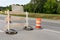 Rear view of a traffic barricade sign and orange and white traffic barrels, road closure, creative copy space