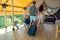 Rear view of traveling couple with baggage entering bedroom of glamping house