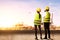 Rear view of Two Asian construction worker with hardhat and safety mask discussing work