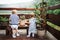 Rear view of two toddler children standing outdoors on a terrace in summer.