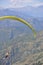 Rear view of unidentified male traveler enjoying paragliding with professional pilot in Himachal Pradesh.