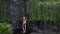 Rear view of woman in beige swimsuit enjoying breathtaking high waterfall Sekumpul in Bali rainforest and raising up