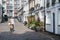 Rear view of woman cycling past mews houses in Paddington, London, UK