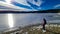 Rear view of woman with hiking backpack watching the frozen lake Forstsee, Techelsberg, Carinthia (Kaernten), Austria,