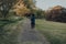 Rear view of a woman running alone in Broomfield Park, Palmers Green, London, UK