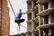 Rear view woman sitting on the two legs on the slackline rope