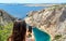 Rear view of woman standing on top of cliff over amazing sea cove in Zavratnica in Croatia.